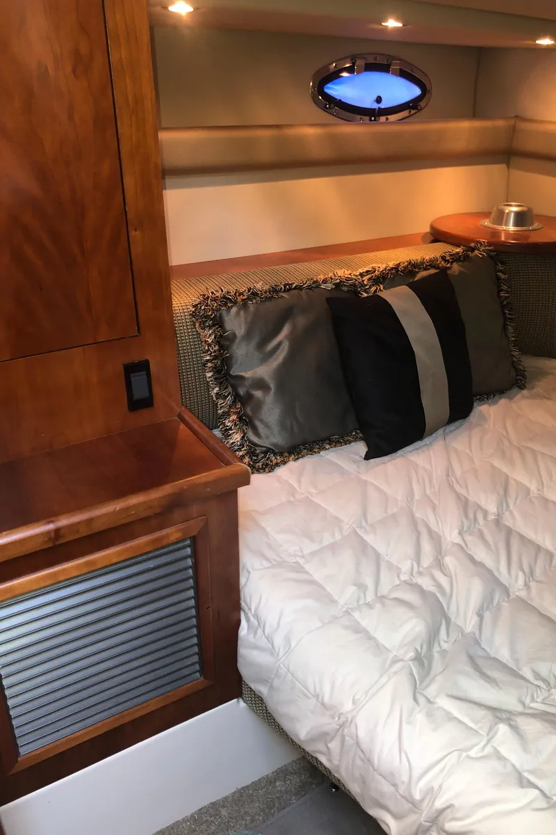 Slide: The Image of Luxurious cabin interior of 2007 Cruisers Yachts 340 Express with cozy bedding and elegant wood finish. - 29