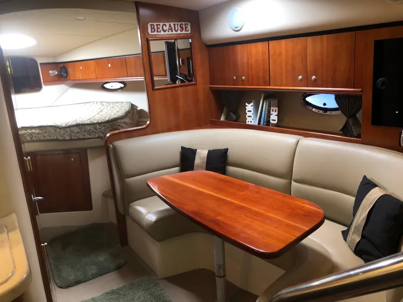 Slide: The Image of 2007 Cruisers Yachts 340 Express interior with cozy seating, wooden table, and elegant cabinetry. - 38