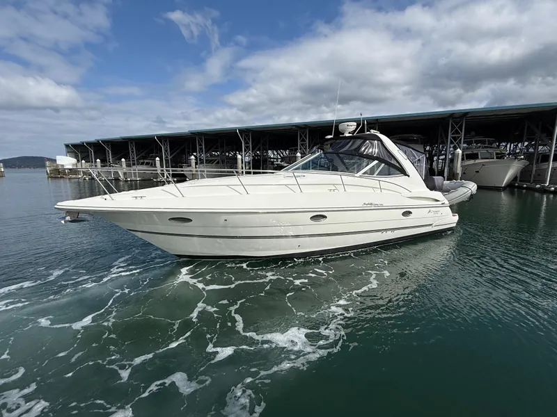 Slide: The Image of 2007 Cruisers Yachts 340 Express in marina, cruising on calm water under cloudy sky. - 4
