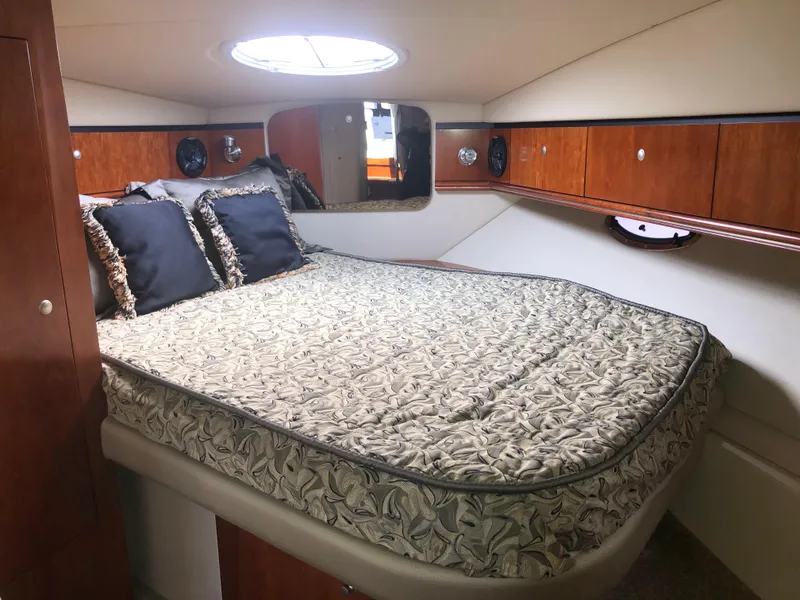 Slide: The Image of 2007 Cruisers Yachts 340 Express cabin with bed, pillows, and wooden storage cabinets. - 41