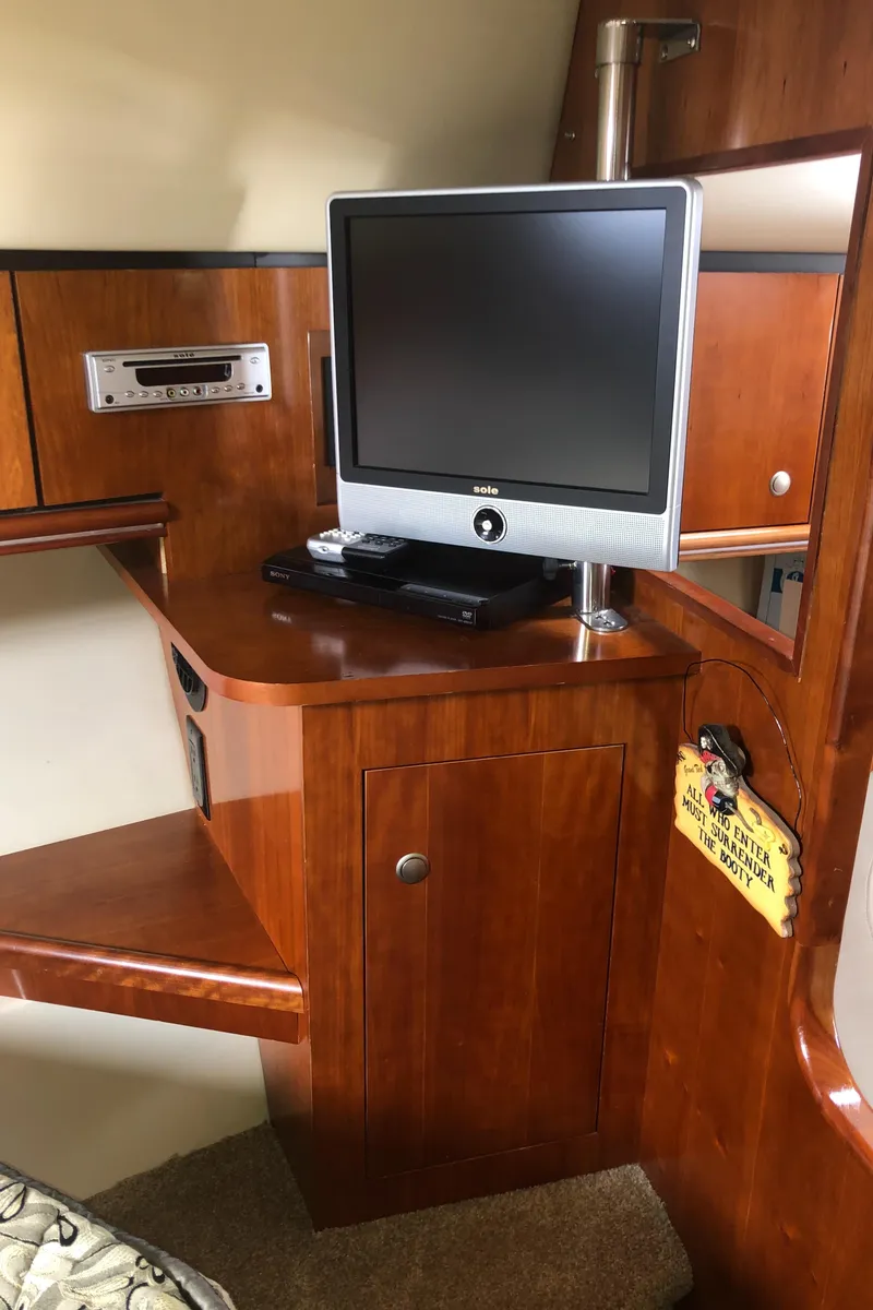 Slide: The Image of 2007 Cruisers Yachts 340 Express interior with TV and wooden cabinetry. - 44