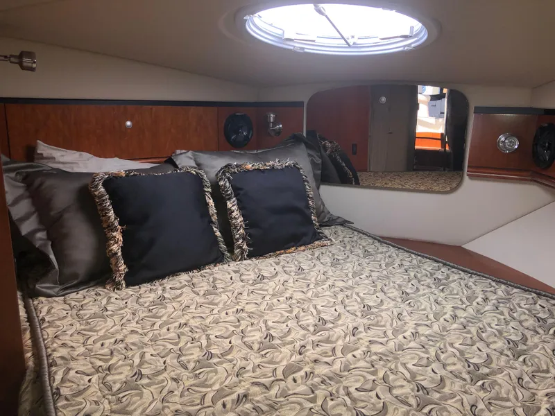 Slide: The Image of 2007 Cruisers Yachts 340 Express cabin with elegant bedding and porthole window. - 48