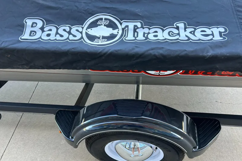 Slide: The Image of 2018 Bass Tracker Heritage boat cover on trailer, showcasing logo and wheel detail. - 14