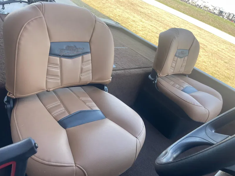 Slide: The Image of 2018 Bass Tracker Heritage boat seats, tan and black upholstery, outdoor setting. - 7