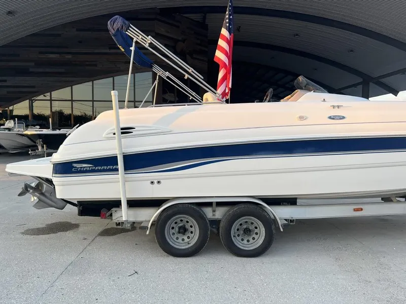 Slide: The Image of 2000 Chaparral Sunesta 252 boat on trailer with American flag, parked outdoors. - 15