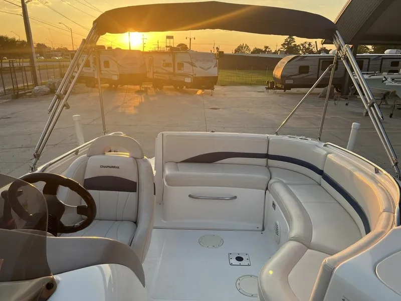 Slide: The Image of 2000 Chaparral Sunesta 252 boat interior with sunset view, featuring white seating and steering wheel. - 9