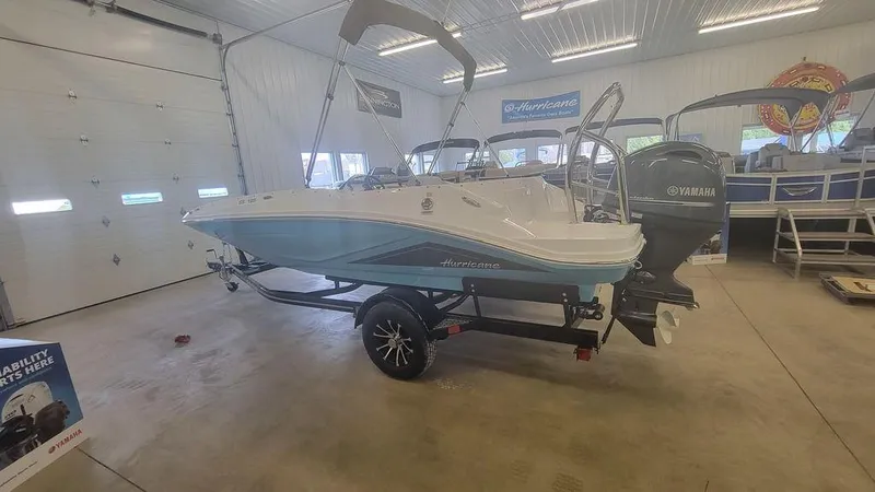 Slide: The Image of 2025 Hurricane SunDeck Sport 185 OB boat in showroom, featuring Yamaha outboard motor. - 10