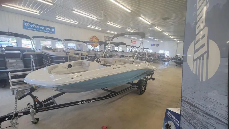 Slide: The Image of 2025 Hurricane SunDeck Sport 185 OB boat displayed in a showroom. - 12