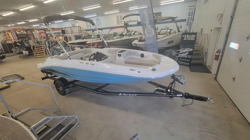 Slide: The Image of 2025 Hurricane SunDeck Sport 185 OB boat displayed in showroom on trailer. - 6