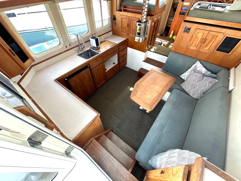 Slide: The Image of Interior of 2004 Nordic Tug 32 with cozy seating, kitchenette, and wooden accents. - 4