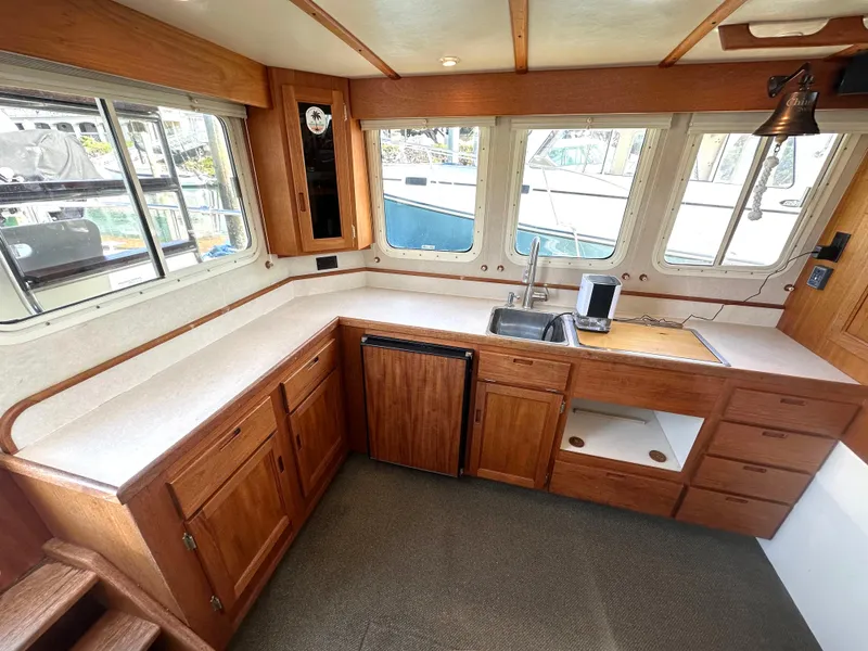 Slide: The Image of Interior of 2004 Nordic Tug 32 with wooden cabinetry and large windows. - 6