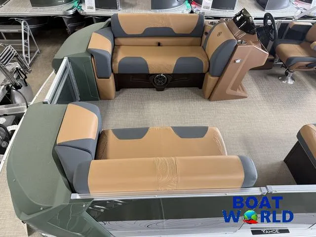 Slide: The Image of 2025 Tahoe Geofish 2385 boat interior with tan and gray seating, steering console, and carpeted floor. - 3