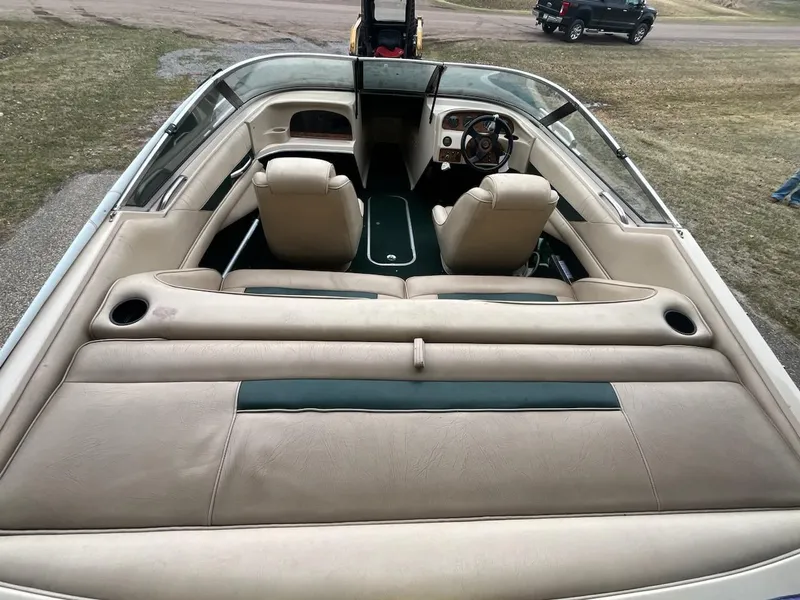 Slide: The Image of 1995 Celebrity 180 Bowrider boat interior with beige seating and steering wheel. - 4