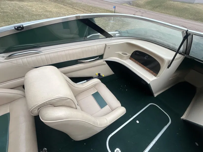 Slide: The Image of 1995 Celebrity 180 Bowrider interior with beige seating and green carpet. - 6