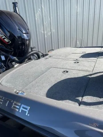 Slide: The Image of 2025 Skeeter ZXR21 boat deck with motor, against a corrugated metal background. - 10