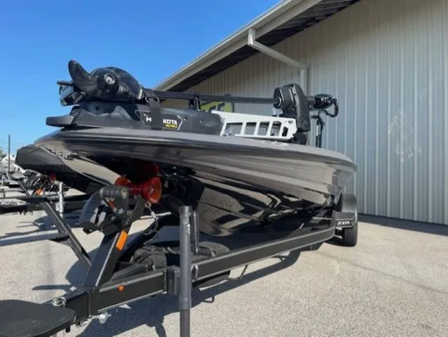 Slide: The Image of 2025 Skeeter ZXR21 boat on trailer, parked outside a metal building. - 3