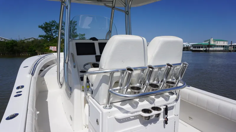Slide: The Image of 2015 Regulator 25 boat with dual seats and rod holders on a sunny day. - 10