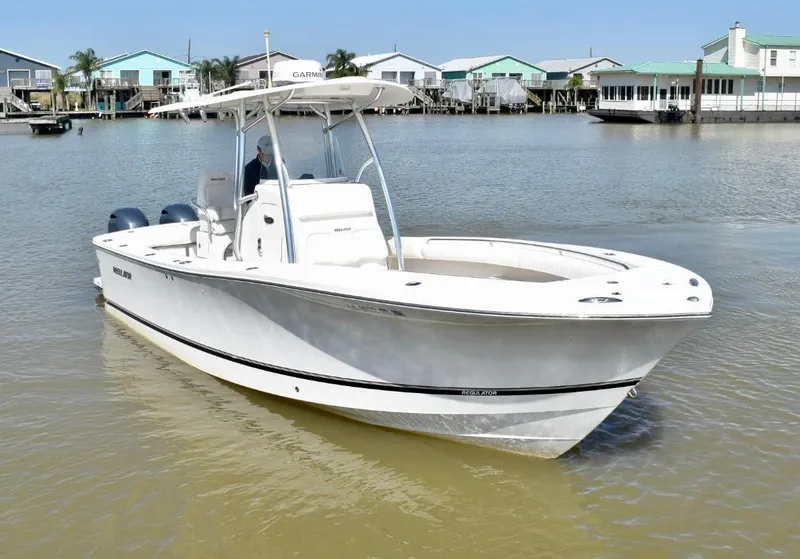 Slide: The Image of 2015 Regulator 25 boat on calm water near colorful waterfront homes. - 4