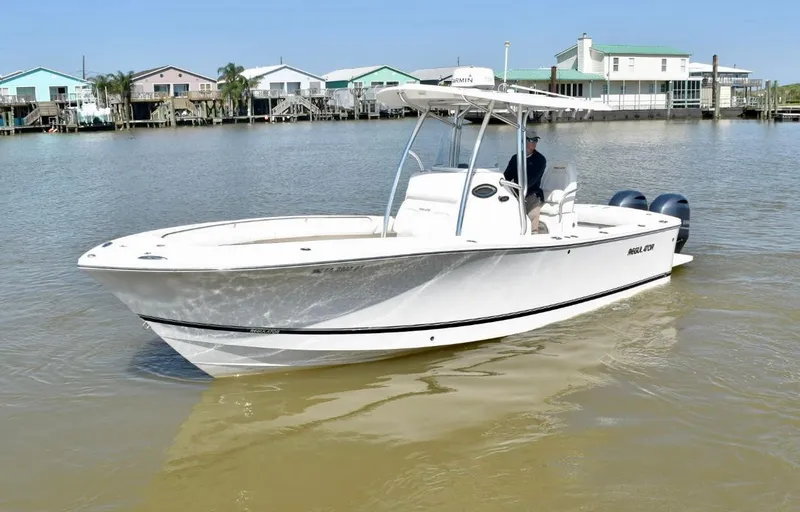 Slide: The Image of 2015 Regulator 25 boat on calm water near waterfront homes. - 7