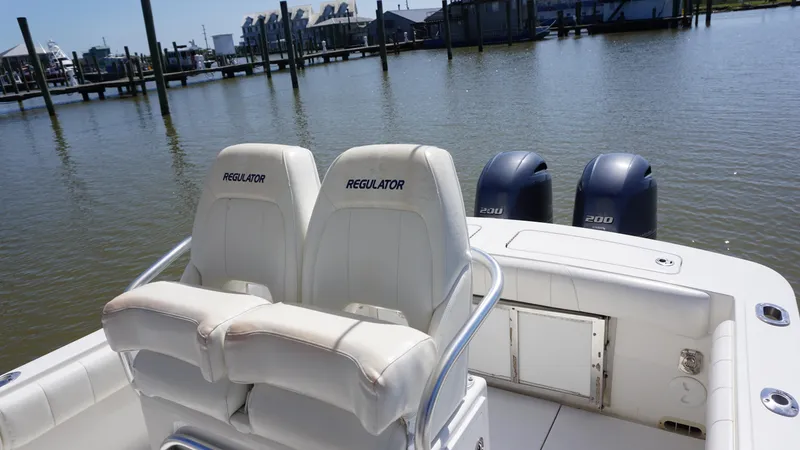 Slide: The Image of 2015 Regulator 25 boat with twin engines docked at a marina. - 9