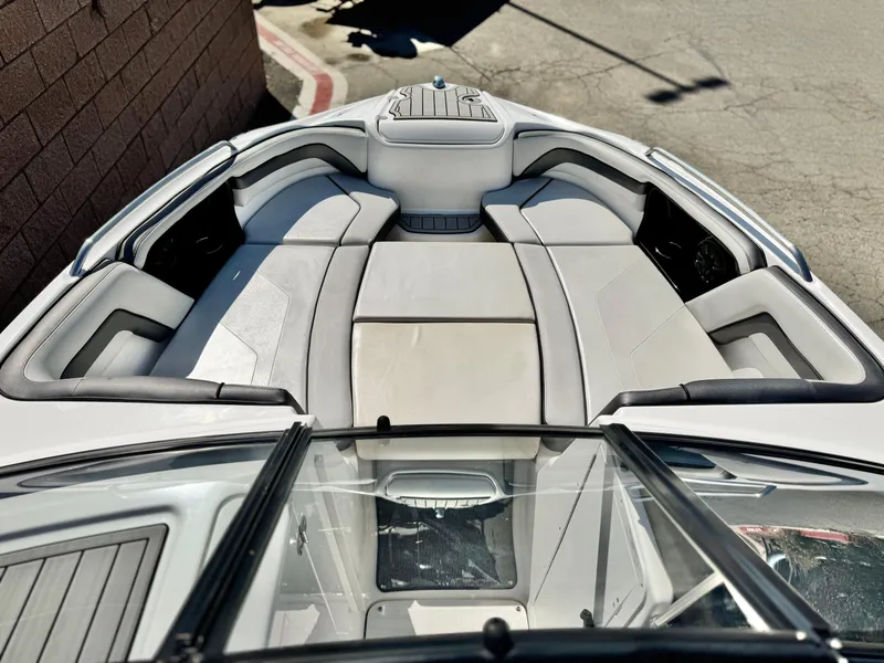 Slide: The Image of 2020 Yamaha Boats AR240 bow seating area with cushioned seats and storage compartments. - 12