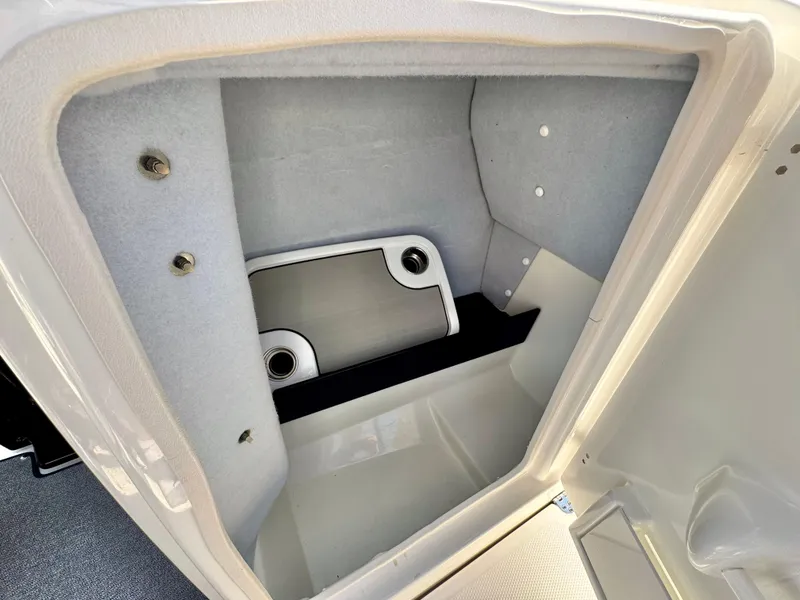 Slide: The Image of Storage compartment in a 2020 Yamaha AR240 boat, featuring a built-in table and cup holders. - 28