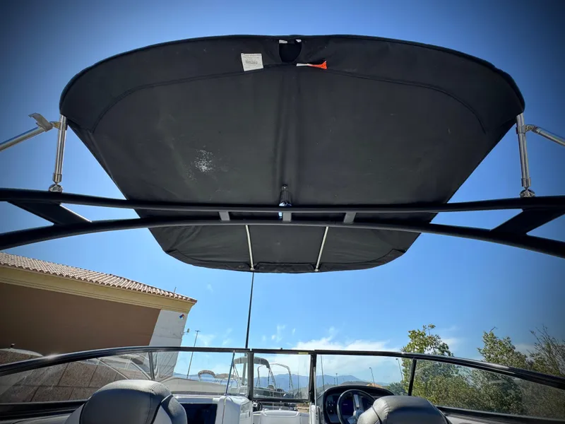 Slide: The Image of 2020 Yamaha AR240 boat with black canopy, clear sky background. - 29