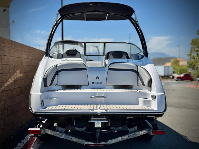 Slide: The Image of 2020 Yamaha Boats AR240, rear view, parked outdoors on a sunny day. - 4