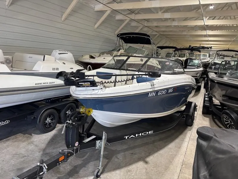 Slide: The Image of 2020 Tahoe 450 TF boat in storage, on trailer, surrounded by other boats. - 1