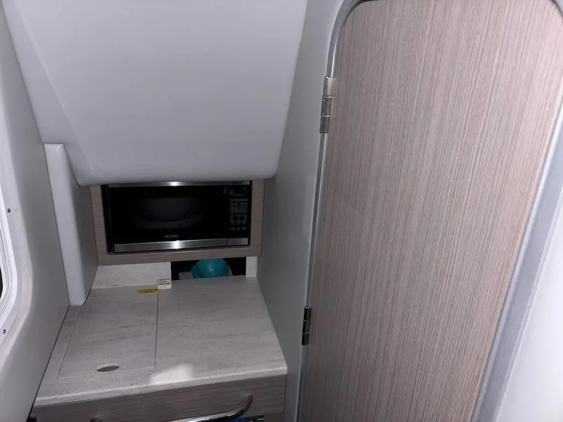 Slide: The Image of 2019 Formula 350 Crossover Bowrider interior with microwave and wooden cabinetry. - 17