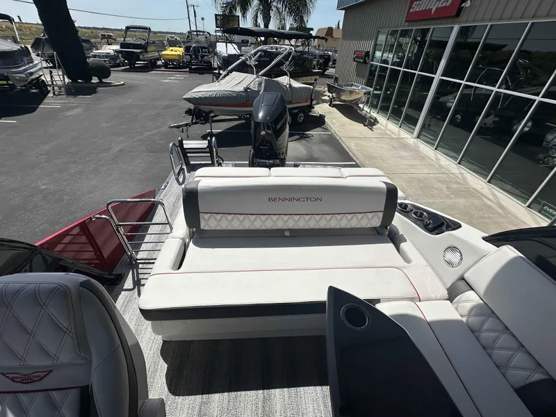 Slide: The Image of 2025 Bennington 25 RXSB boat interior with luxurious seating at a dealership. - 13