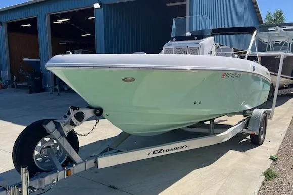 Slide: The Image of 2019 Wellcraft 18 CC boat on EZ Loader trailer outside a blue warehouse. - 1