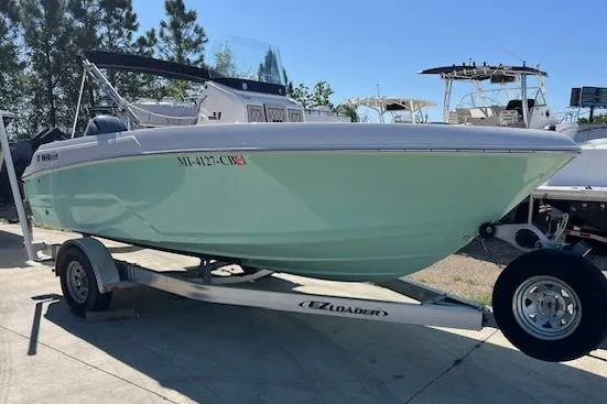 Slide: The Image of 2019 Wellcraft 18 CC boat on trailer, light green hull, parked outdoors. - 2