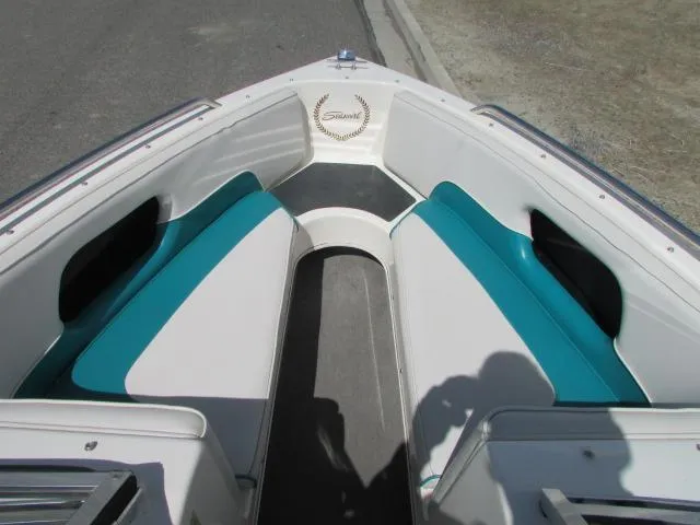 Slide: The Image of Bow seating area of a 1995 Seaswirl 180 boat with teal and white upholstery. - 12