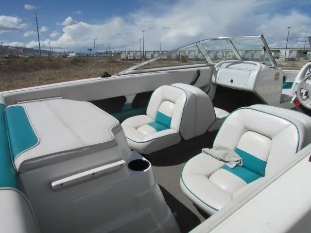 Slide: The Image of 1995 Seaswirl 180 boat interior with white and teal seating, open cockpit, and clear skies. - 3
