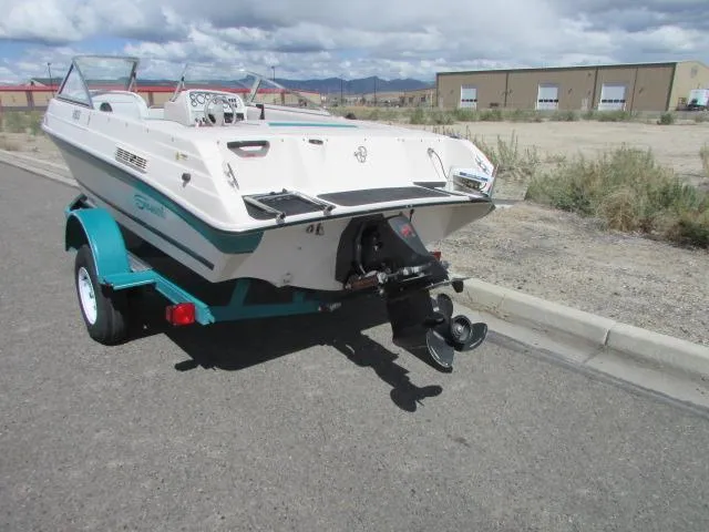 Slide: The Image of 1995 Seaswirl 180 boat on trailer, parked on roadside under cloudy sky. - 6