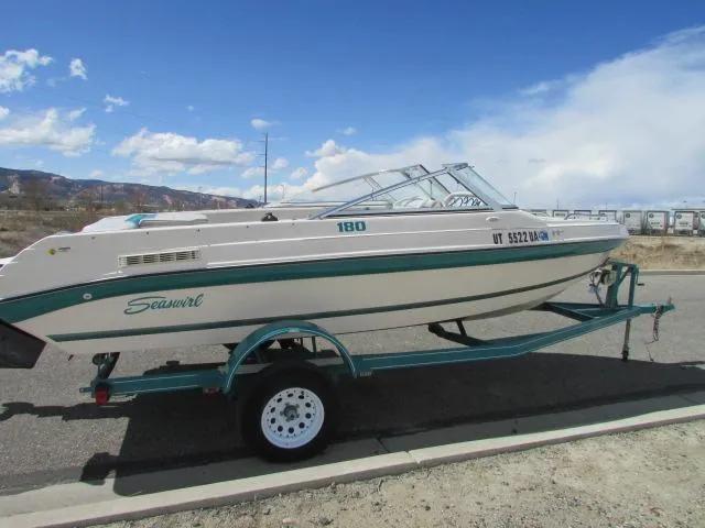 Slide: The Image of 1995 Seaswirl 180 boat on trailer, parked roadside under clear blue sky. - 7