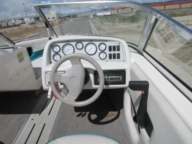 Slide: The Image of 1995 Seaswirl 180 boat dashboard with steering wheel and gauges on a sunny day. - 8