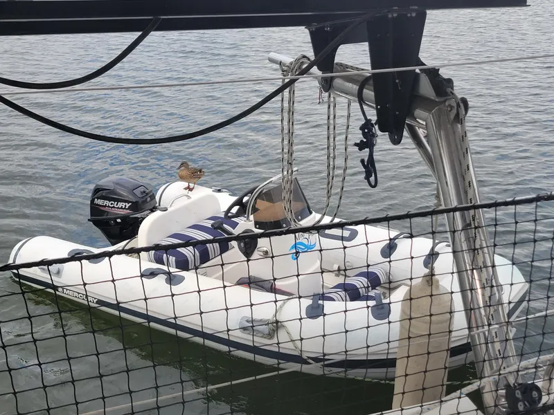 Slide: The Image of Inflatable boat with Mercury engine on water, viewed from Lagoon 450 catamaran. - 22