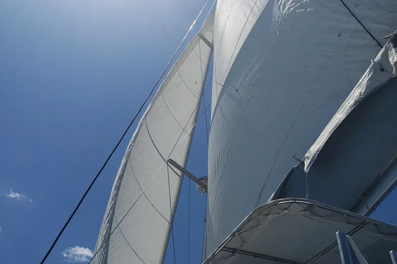 Slide: The Image of Sails of a 2011 Lagoon 450 catamaran against a clear blue sky. - 25