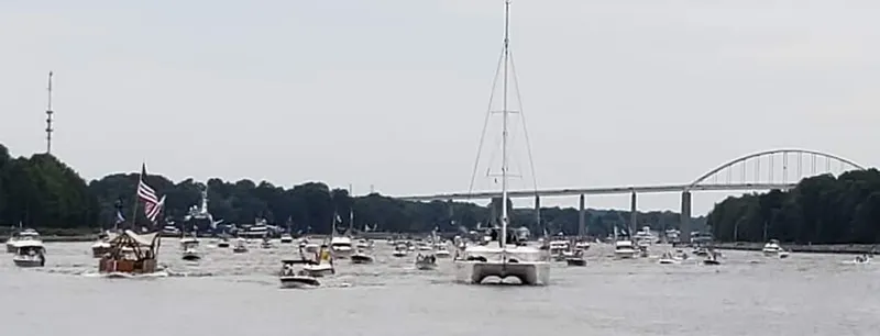 Slide: The Image of Boats on a river with a bridge in the background, featuring a 2011 Lagoon 450. - 37