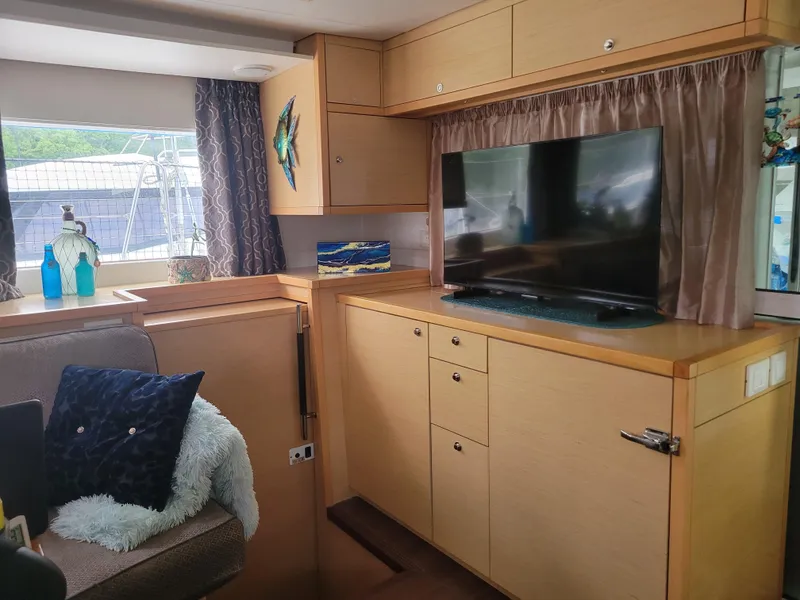 Slide: The Image of Interior of 2011 Lagoon 450 yacht with TV, cabinets, and cozy seating area. - 4
