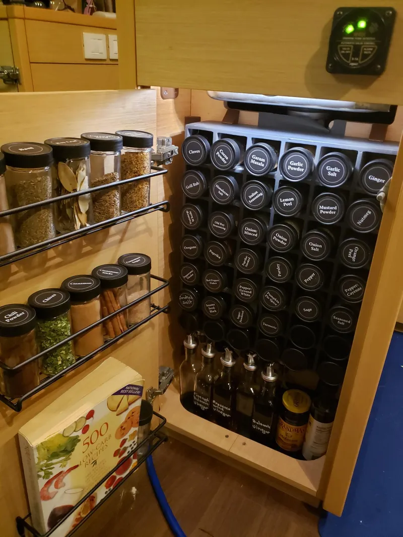Slide: The Image of Spice rack in a Lagoon 450 yacht kitchen, neatly organized with labeled jars and bottles. - 6