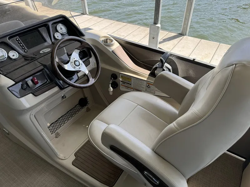 Slide: The Image of 2015 Premier 270 Grand Isle SL boat helm with steering wheel and captain's chair. - 5