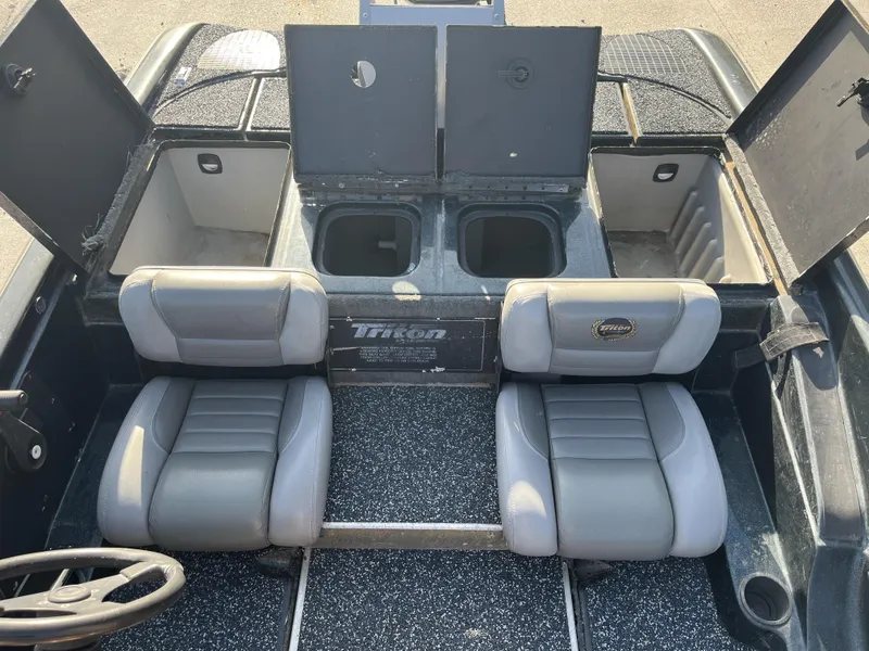 Slide: The Image of 1998 Triton Tr-17 boat interior with two seats and open storage compartments. - 12