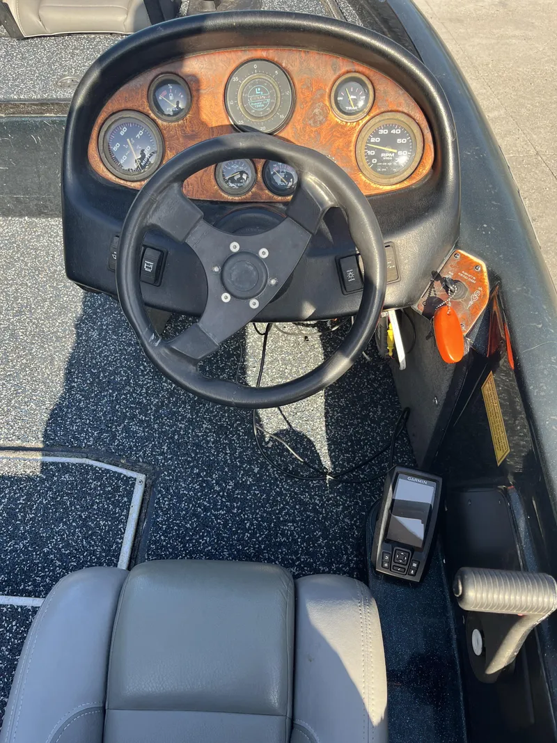 Slide: The Image of 1998 Triton Tr-17 boat dashboard with steering wheel and gauges. - 13