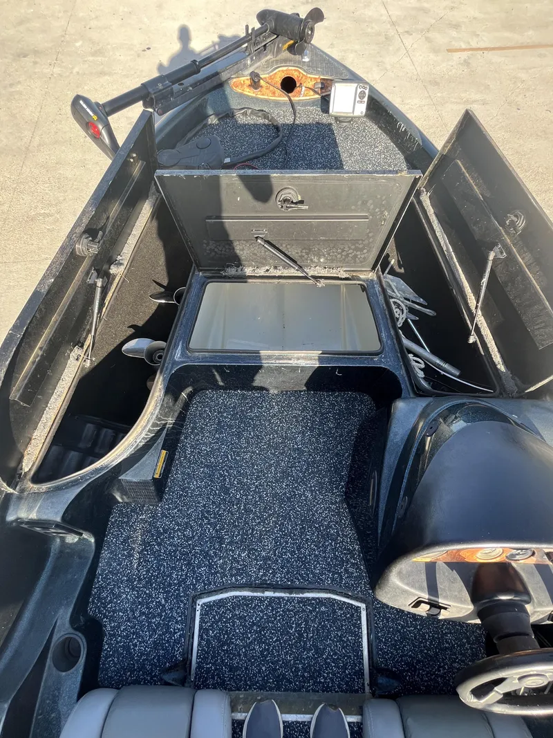Slide: The Image of 1998 Triton Tr-17 boat interior with open storage compartments and steering wheel. - 14