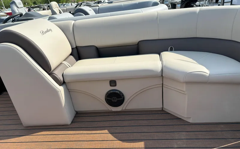 Slide: The Image of 2025 Bentley Pontoons Legacy 223 Swingback interior seating with beige upholstery and speaker. - 4