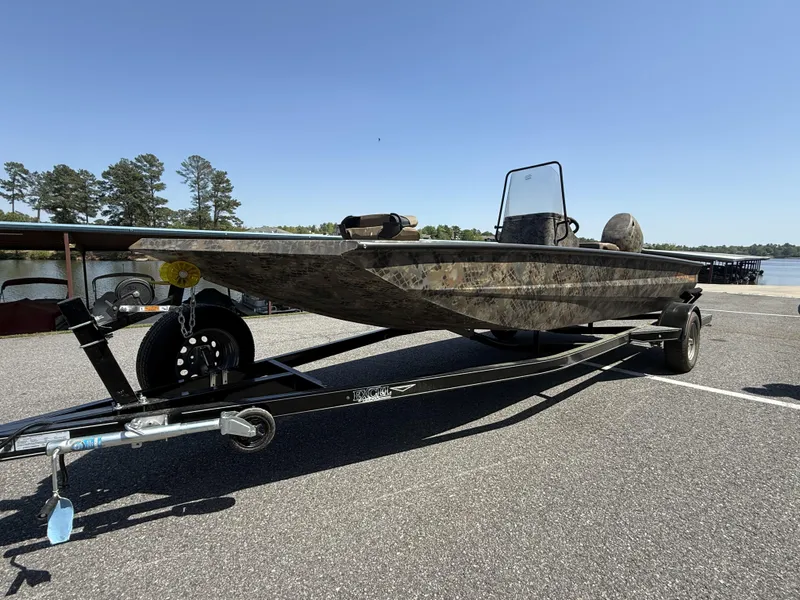 Slide: The Image of 2025 Excel Stalker Center Console 1960 boat on trailer, parked near a lake. - 4