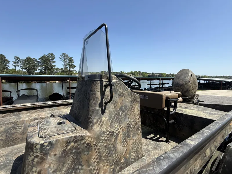 Slide: The Image of 2025 Excel Stalker Center Console 1960 boat with camouflage design, docked by a serene lake. - 5